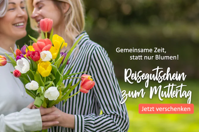 Zwei lächelnde Frauen mit einem bunten Tulpenstrauß vor grünem Hintergrund. Text: Reisegutschein zum Muttertag. Orangener Button: Jetzt verschenken.